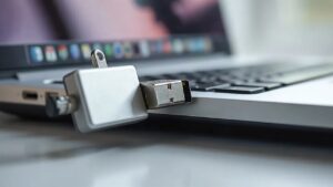 Dizüstü bilgisayarın yan portundan yarı çıkarılmış metal USB bellek; Windows USB geçmişine kaydolan depolama aygıtı (Temsili görsel)